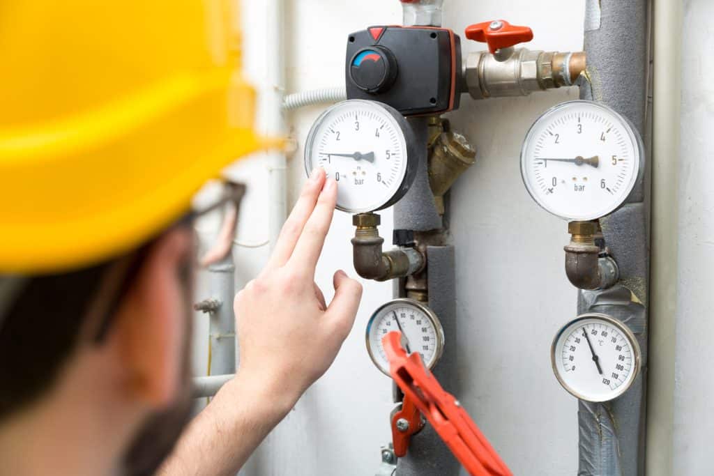 technician checking pressure meters